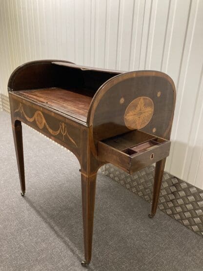 Side view of desk with tambour partially open and writing pad laying flat, draw also open